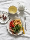 Cozy homemade brunch - omelette with arugula, cherry tomatoes, whole grain toast, green tea, chocolate dessert on a light