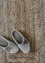 Cozy homemade felt homemade beige slippers on a jute rug top view Royalty Free Stock Photo