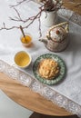Cozy homemade morning - crumble, almond petals bun, honey, green tea on a round wooden table, top view