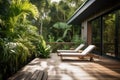 cozy house exterior with sunbathing deck and lounge chairs, surrounded by lush greenery