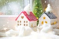 Cozy house is wrapped in a hat and scarf in a snowstorm -window sill decor for Christmas, New Year. Winter, snow - home insulation Royalty Free Stock Photo