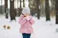 Cozy ideas for winter picnic outdoors. Little child girl enjoys winter hot drink, standing among the winter snowy trees Royalty Free Stock Photo