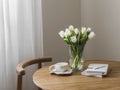 Cozy interior - a bouquet of tulips in a vase, a cup of tea, books on a round wooden table Royalty Free Stock Photo