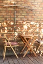 Cozy Interior Courtyard with table. Empty street coffee shop with wooden terrace and brick wall. Royalty Free Stock Photo