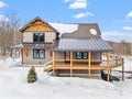 Cozy and inviting custom home situated in a winter landscape, surrounded by snow-covered trees Royalty Free Stock Photo