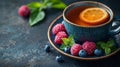 Cozy cup of tea with berries and citrus on a blue surface Royalty Free Stock Photo