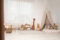 Cozy kids room with play tent, toys and floor bed. Montessori interior Royalty Free Stock Photo