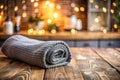 Cozy Kitchen Essentials RolledUp Grey Microfiber Tea Towel on Rustic Wood Enhanced by Soft Bokeh Royalty Free Stock Photo