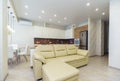 Cozy kitchen-living room with a new renovation. White leather sofa in the center.