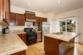 Cozy kitchen room with tile counter top, kitchen island and stainless steel fridge Royalty Free Stock Photo