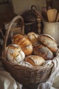 A cozy kitchen scene featuring a rustic basket filled with various types of freshly baked breads, Royalty Free Stock Photo