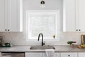 A cozy kitchen sink detail shot in a white kitchen. Royalty Free Stock Photo