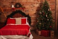 A cozy large double bed next to the Christmas tree on a holiday evening