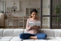 Interested latin woman sit on couch enjoy hobby reading book