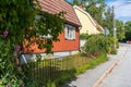 Cozy little old red and yellow wooden houses. The roofs are covered with tiles. Decorative garden design with green hedges of