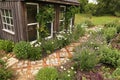Cozy Little Rustic Shed with Stone and Brick Path in Cottage Garden Royalty Free Stock Photo