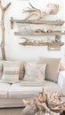 Cozy living room corner with white sofa, decorative pillows, and rustic wooden shelves filled with seaside decor Royalty Free Stock Photo