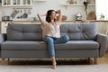 In cozy living room happy woman sitting on couch alone Royalty Free Stock Photo
