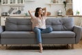 In cozy living room happy woman sitting on couch alone