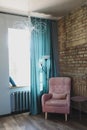 cozy living room with a pink armchair by the window, modern loft interior Royalty Free Stock Photo