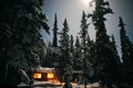 Cozy log cabin at moon-lit winter night