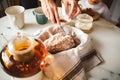 A cozy meal with family, tea drinking, a female hand cuts a cupcake with a knife