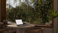 A cozy minimalist cafe or coffee shop on a rainy day, a laptop mockup on a table