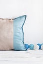 Cozy minimalist home decor. Soft pillow and blue balls on a white old wooden table, shabby backdrop. Scandinavian style Royalty Free Stock Photo