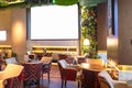 Cozy modern interior of restaurant, teahouse with white projector screen