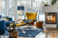 Cozy modern living room with yellow chair, blue sofa and warm fireplace Royalty Free Stock Photo