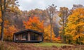 A cozy modern wooden cabin surrounded by colorful autumn foliage Royalty Free Stock Photo