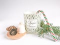 Cozy moments with aromatic candle, bell, pine cones and christmas tree on a white background.