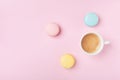 Cozy morning breakfast. Cup of coffee and colorful macaron on pastel pink background. Fashion flat lay. Sweet macaroons.