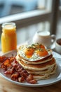 Cozy morning breakfast with pancakes, bacon, eggs, and fresh orange juice Royalty Free Stock Photo