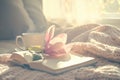 Cozy Morning with Coffee, Open Book, Soft Blanket, and Flower in Sunlight Royalty Free Stock Photo