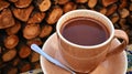 Cozy Mug of Hot Cocoa on a Saucer Near a Stack of Fireplace Logs in a Warm Setting Royalty Free Stock Photo