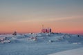 Cozy northern guest house on a snowy hill at dawn. Cabin in winter dawn. Lonely house on a hilltop in the cool morning