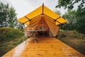 Cozy open glamping tent with light inside during dusk. Luxury camping tent for outdoor summer holiday and vacation. Lifestyle Royalty Free Stock Photo