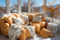 Cozy orange sofa with pillows and blankets and a vase by the window with a mountain view. Copy spce Royalty Free Stock Photo