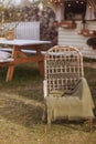 Cozy outdoor courtyard with wicker chair and green blanket.