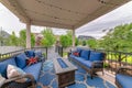 Cozy outdoor deck with fire pit table and woven sofas with blue cushions