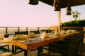 Cozy outdoor dining area with a rustic wooden table with coffee mugs Royalty Free Stock Photo