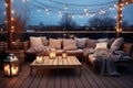 Cozy outdoor roof terrace with a sofa and coffee table is decorated with garlands and lamps