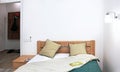 Cozy pan-bedroom interior with a green bedspread, two pillows, a luminous sconce, a book on the bedspread with a door to the Royalty Free Stock Photo