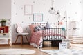 Pastel pink woolen blanket on single industrial bed in scandinavian bedroom interior for teenager