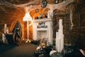 The cozy photo area is decorated for Halloween with a fireplace and an armchair and All Hallows Even elements. Halloween decor