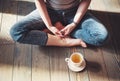 Cozy photo of young woman with cup of tea sitting on the floor