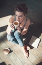 Cozy photo of young woman with cup of tea sitting on the floor