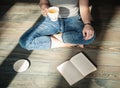 Cozy photo of young woman with cup of tea sitting on the floor