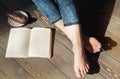 Cozy photo of young woman feet with book and cake on the floor